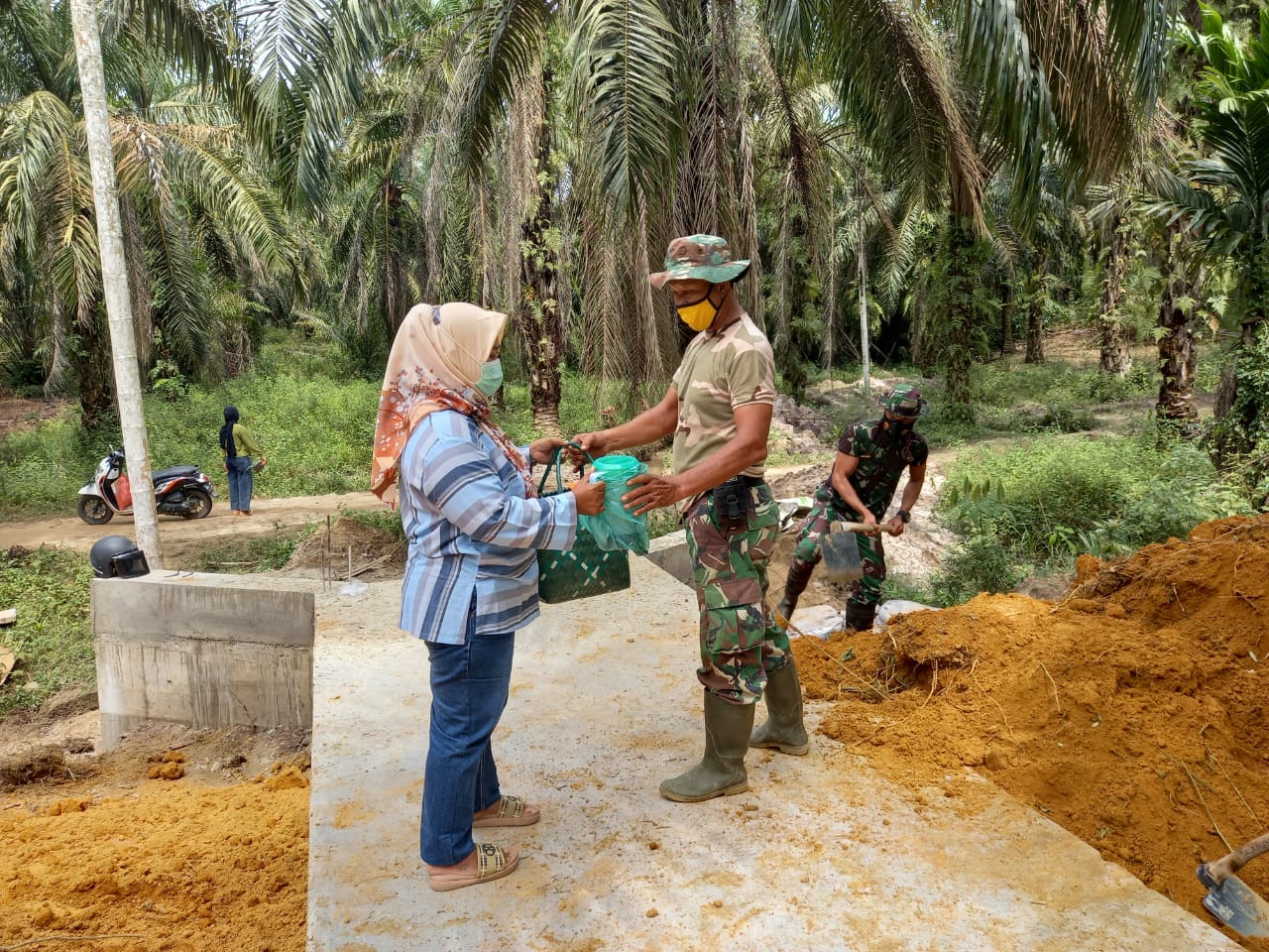 Melihat anggota Satgas TMMD kelelahan, Bu Yustini beri makanan dan  minuman ringan